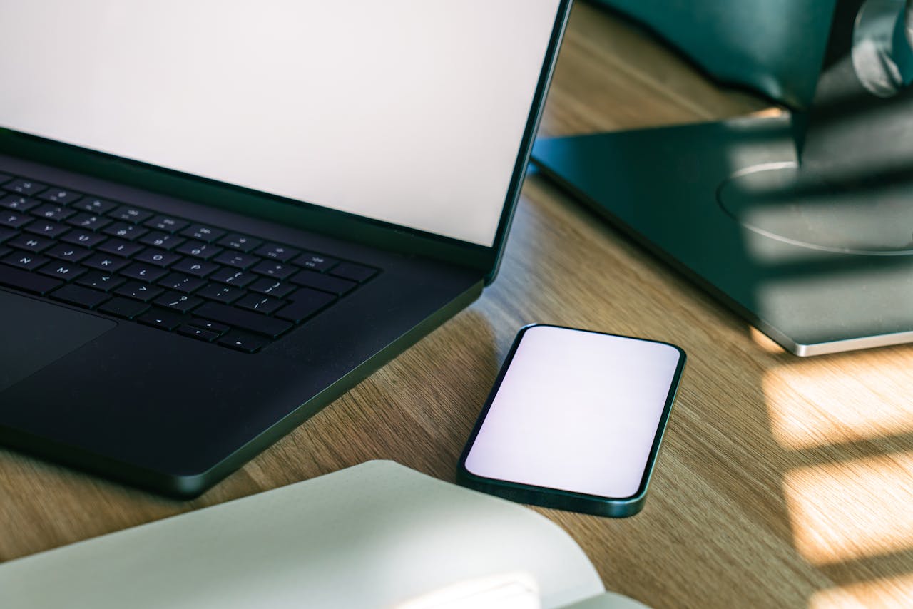 A sleek office desk setup featuring a laptop and smartphone, ideal for tech and business themes.